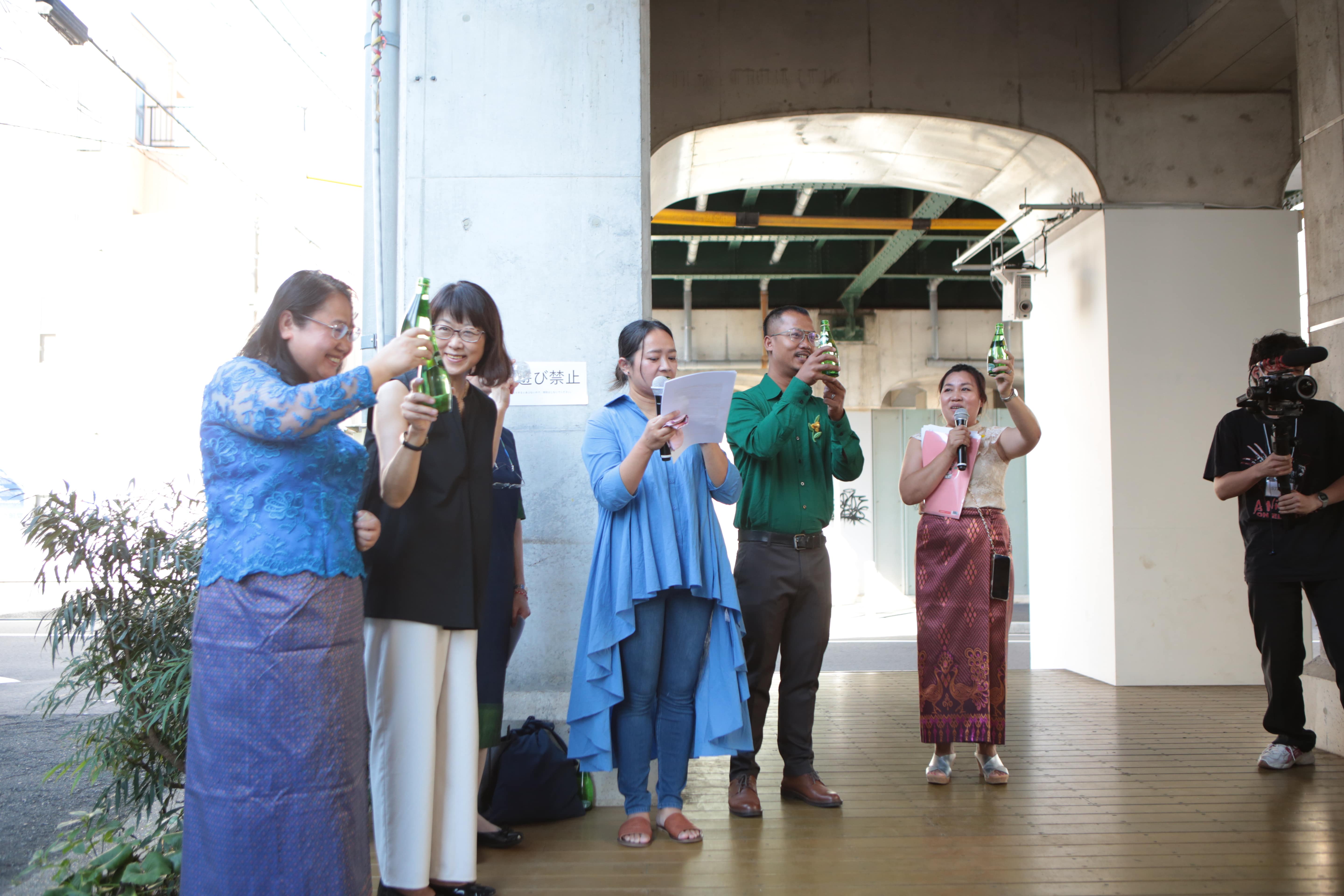 Slider Image Kim Hak and various other people raise their glasses for a toast at the exhibition opening