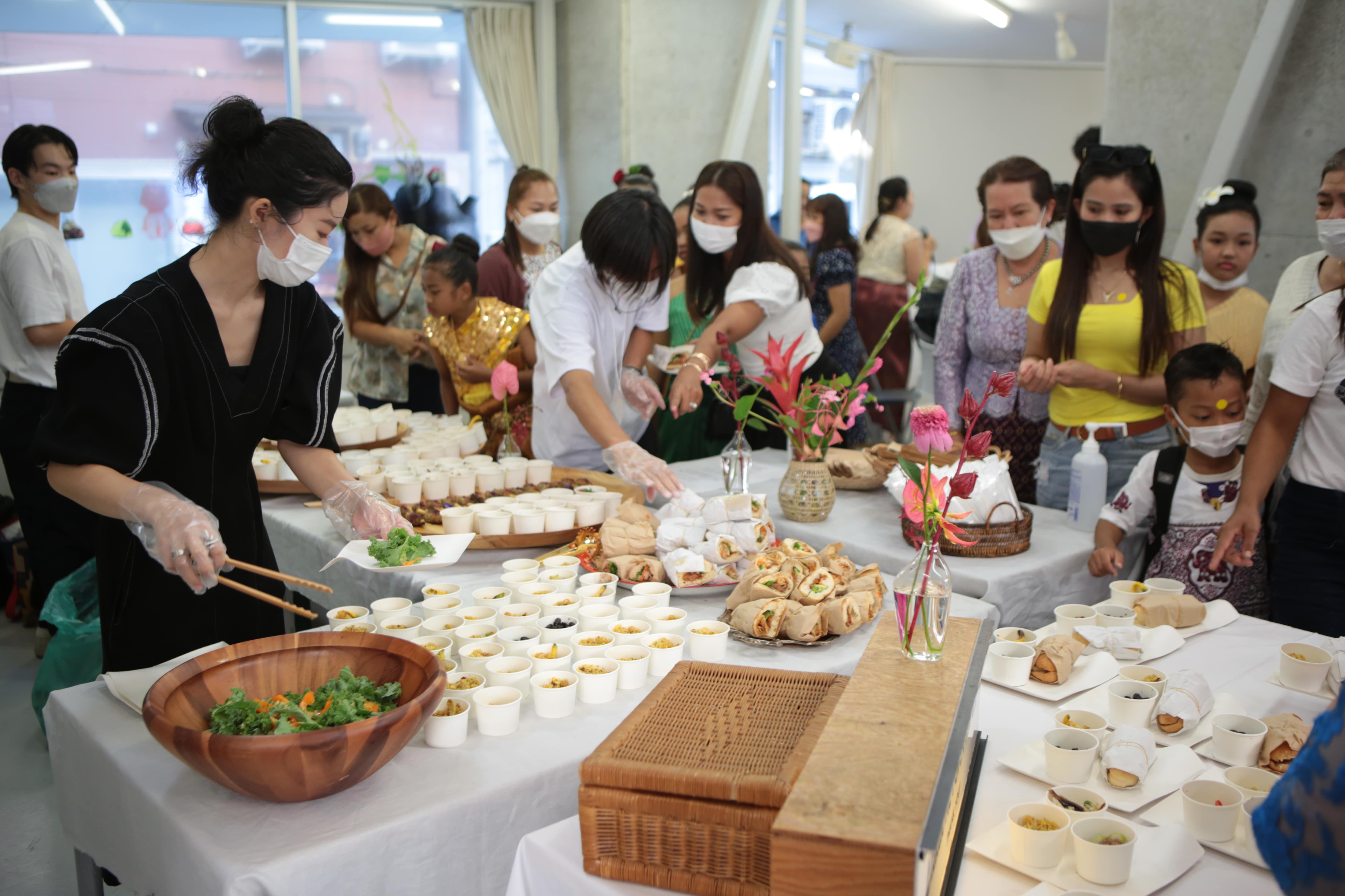 Slider Image A spread of sandwiches and salad is served to attendees at the exhibition launch