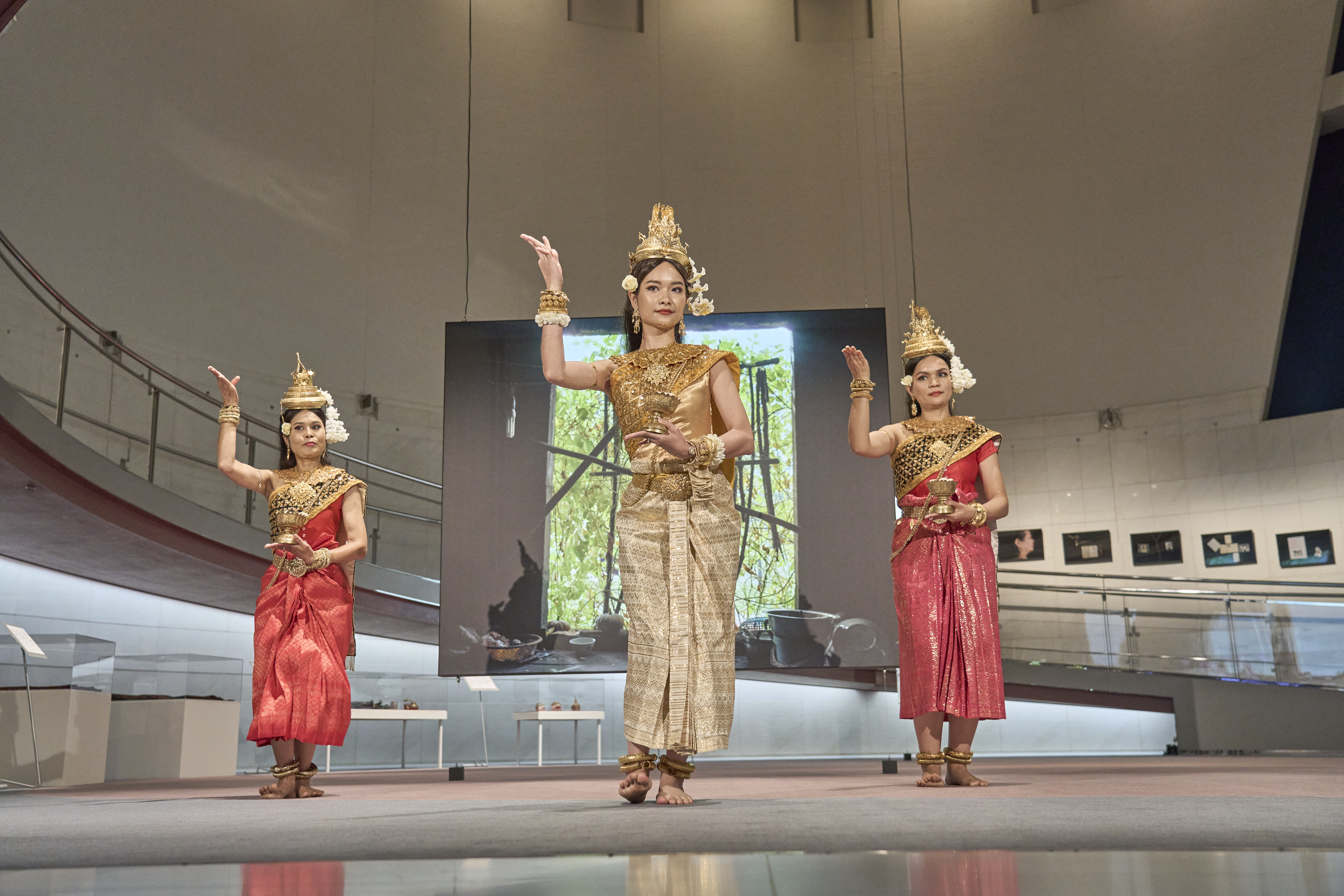 Slider Image Three women in traditional costumes dance a traditional Cambodian dance