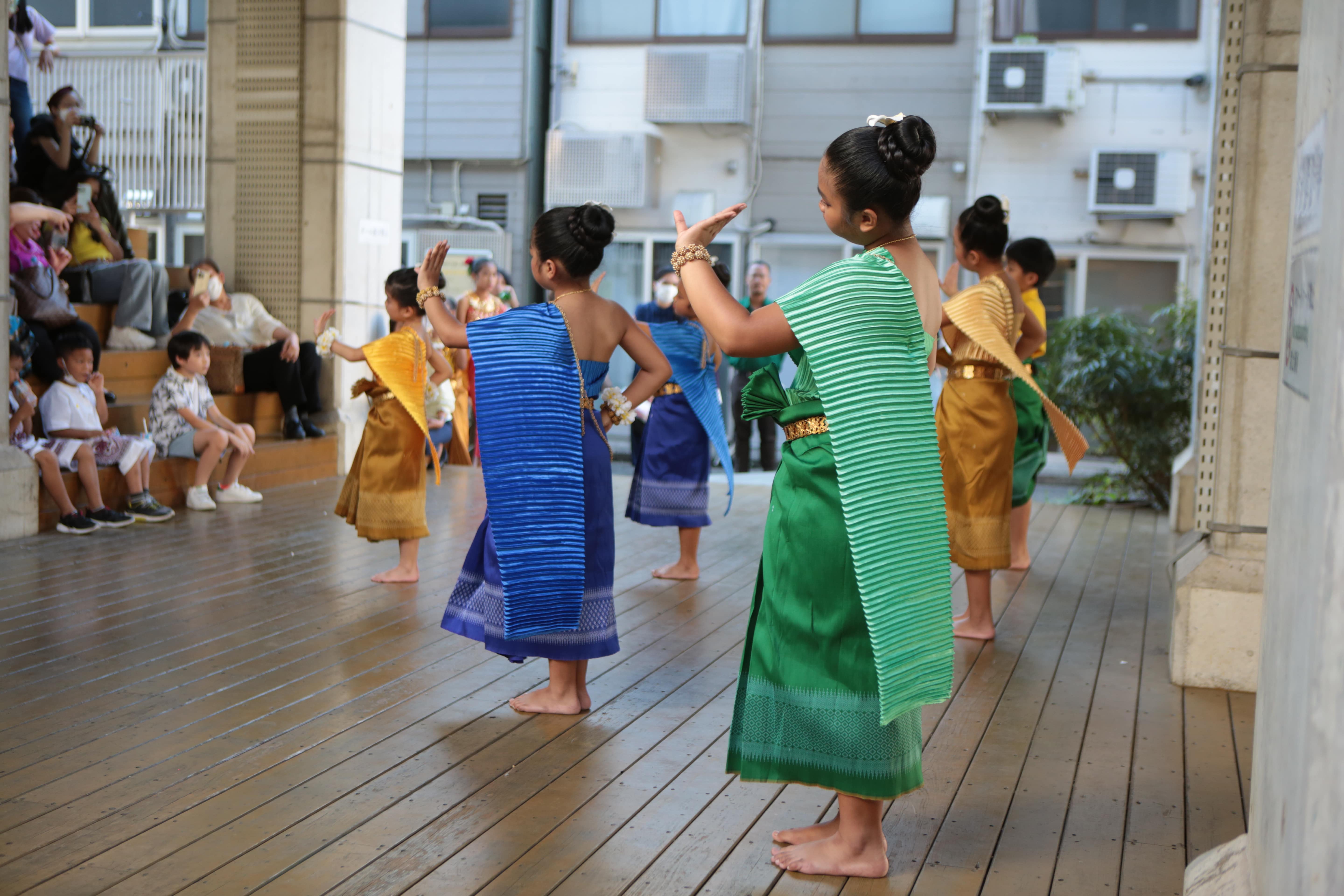 Slider Image A group of young girls perform a Cambodian traditional dance on a stage in front of an audience