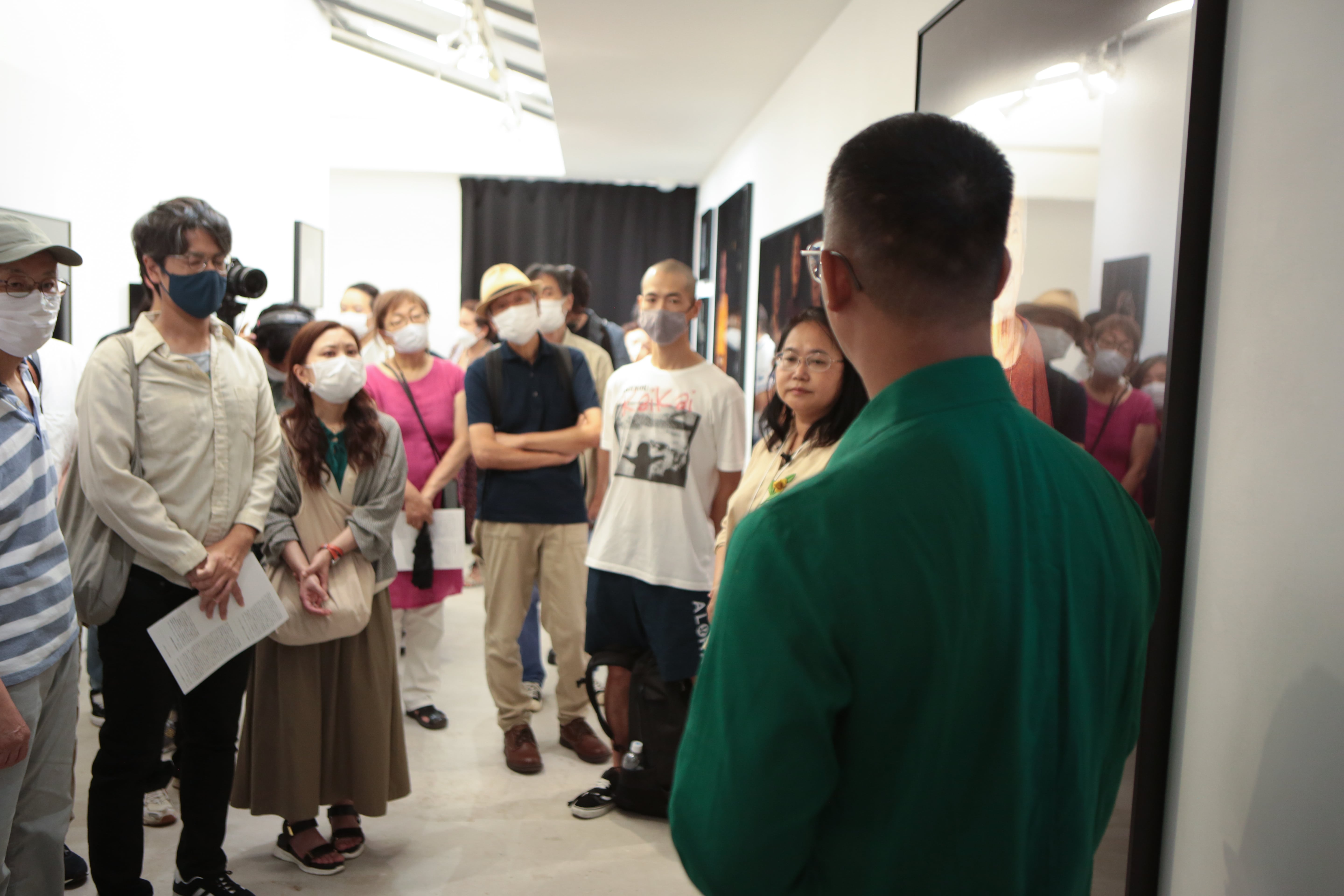 Slider Image A group of people listen to Kim Hak giving an exhibition talk